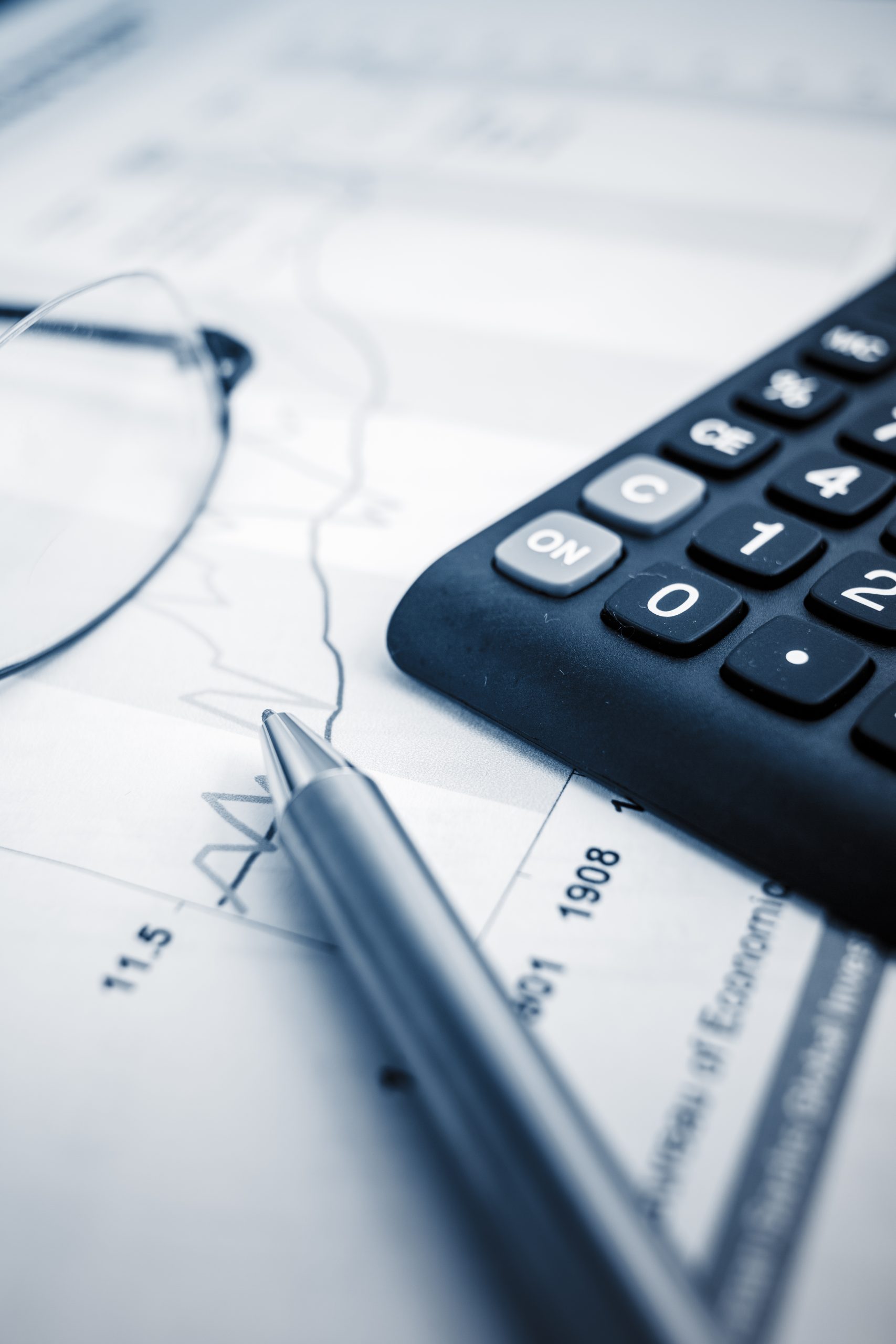 glasses on the finance chart on the desk.